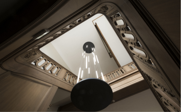 Prise de vue par le dessous d'un escalier en colimaçon et d'un lustre au centre